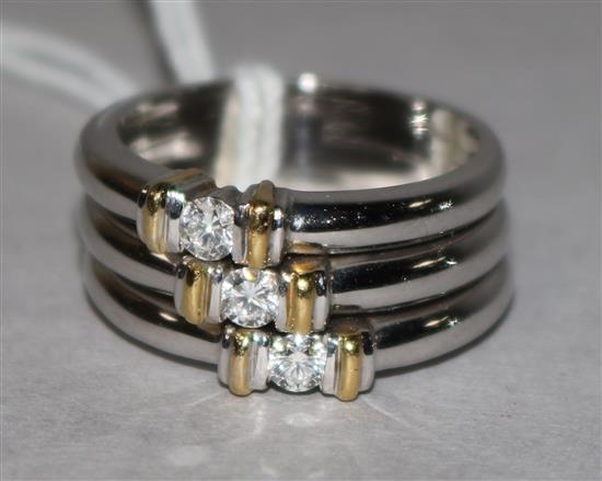 A modern 18ct white gold and three stone diamond triple band ring, size O.